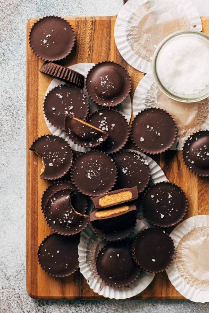 peanut butter cups scattered on a wood tray