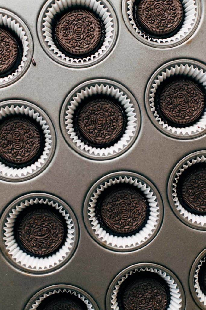 oreos placed on top of brownie filled cupcake liners