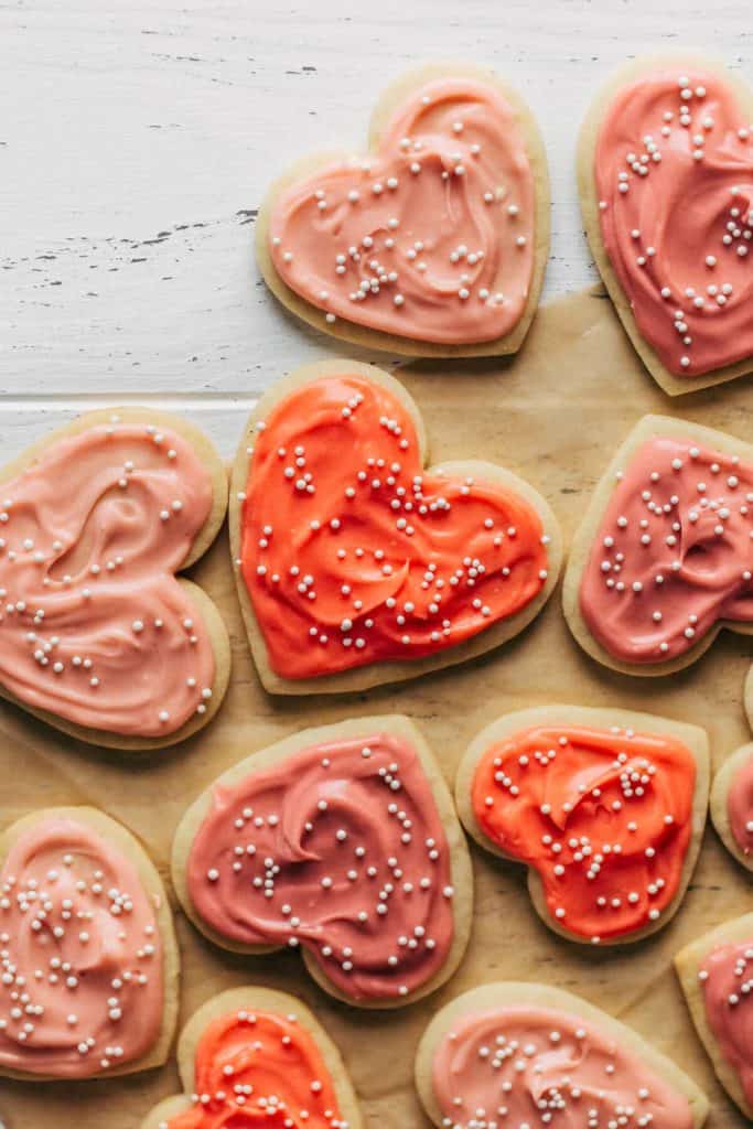 close up on heart sugar cookies topped with colorful cream cheese frosting