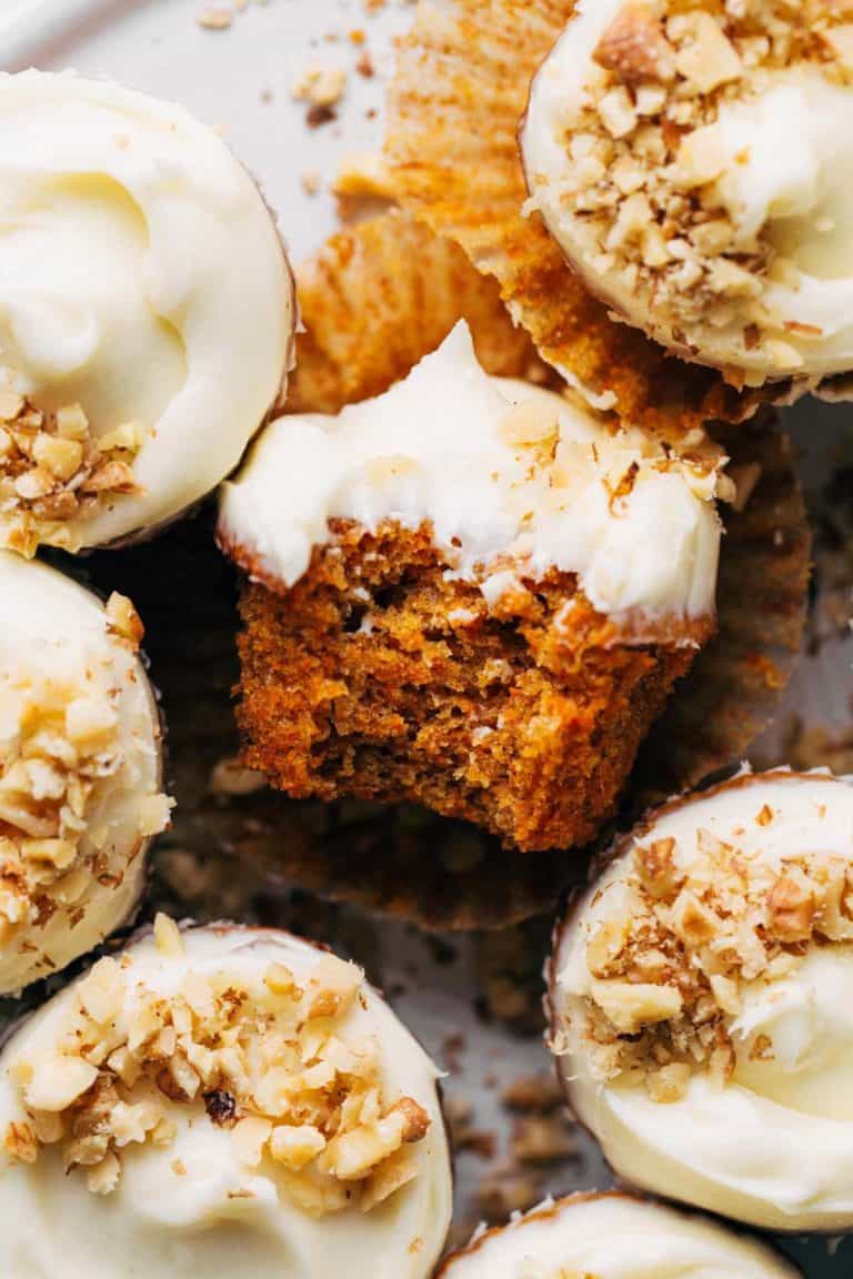 close up on a bite taken out of a carrot cake cupcake