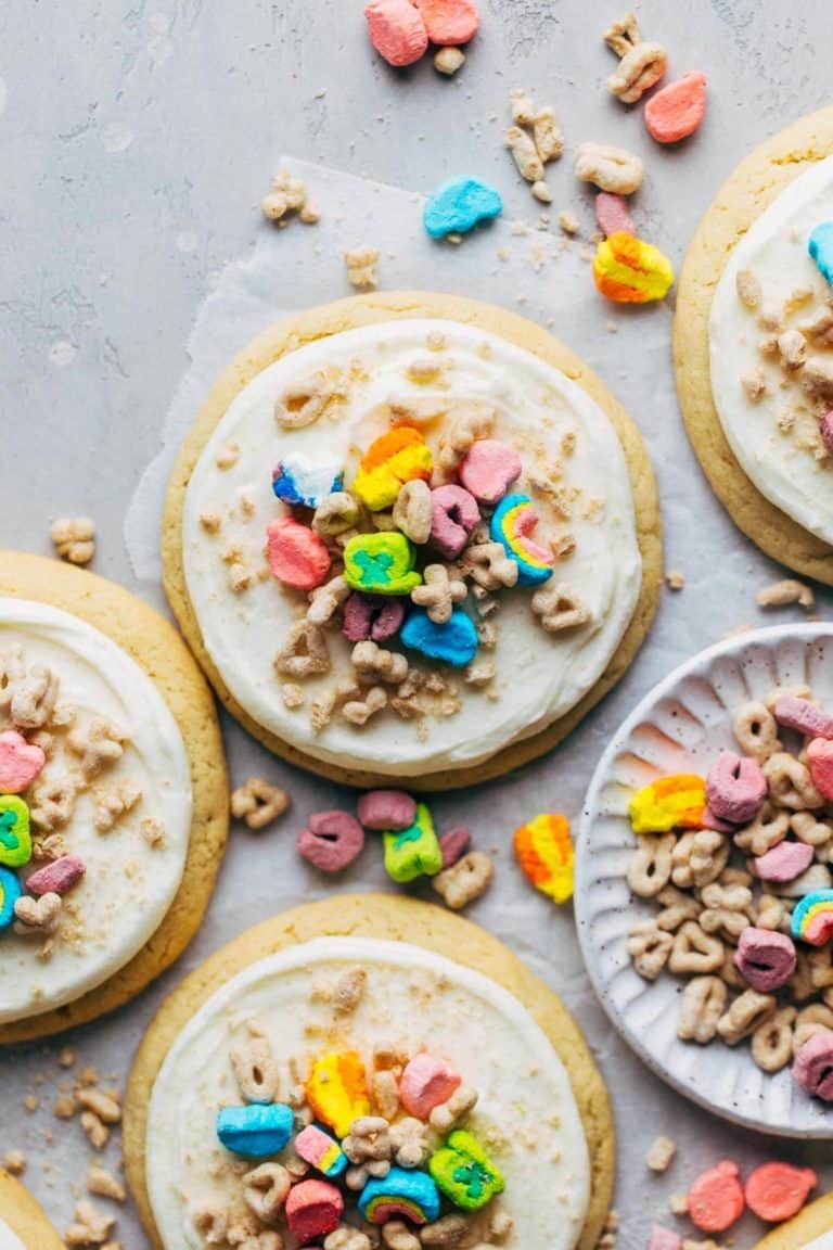 the top view of a sugar cookie topped with frosting and Lucky Charms cereal