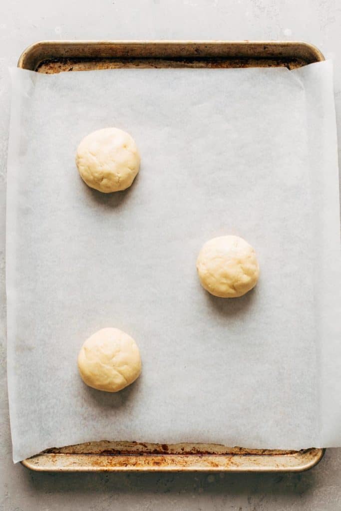three balls of cookie dough on a baking sheet