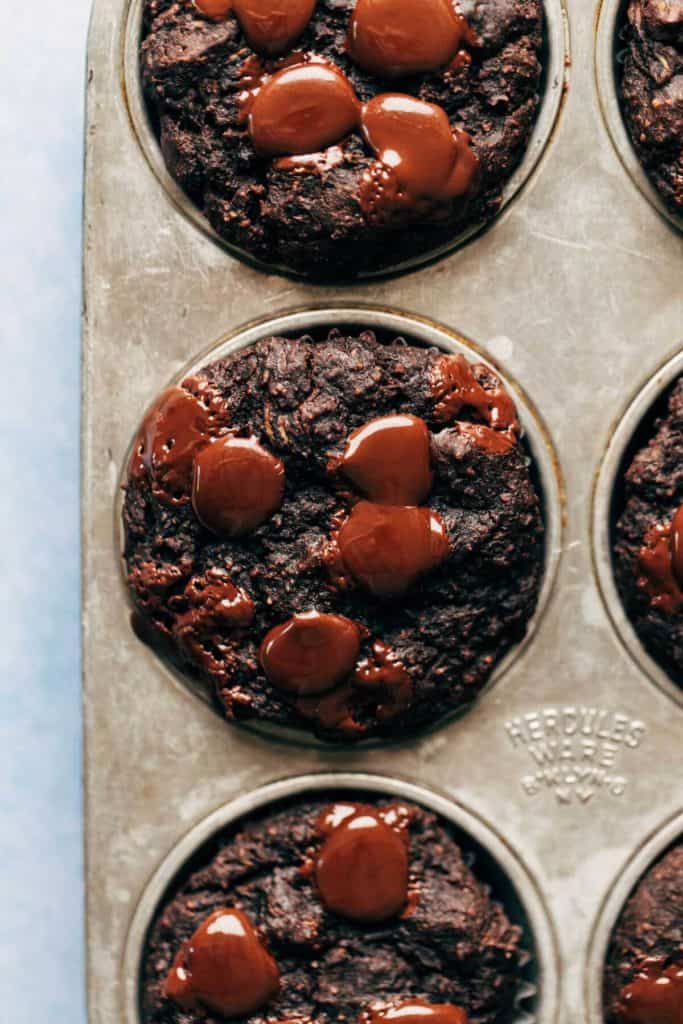 the top of a freshly baked chocolate zucchini muffin with chocolate puddles on top