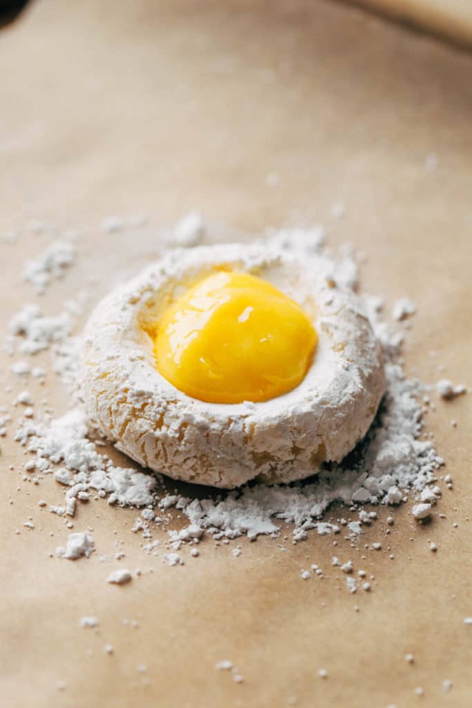 a smashed butter cookie dough ball with lemon curd placed in the centerr