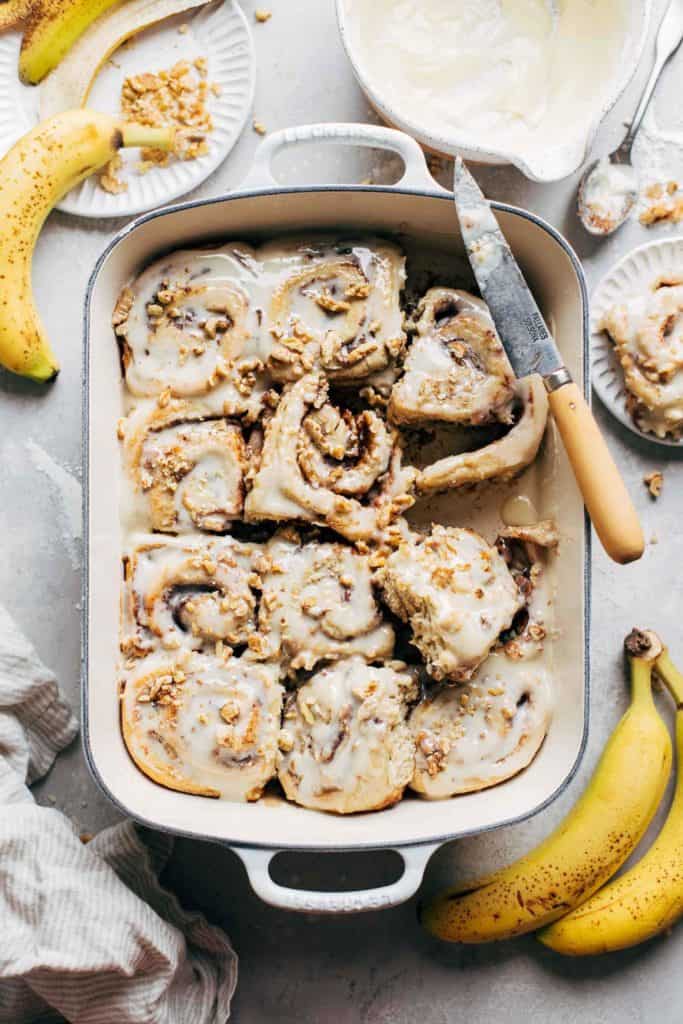 the top of a pan of banana cinnamon rolls covered in icing