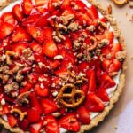 the top of a finished strawberry tart sprinkled with a pretzel crumble