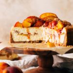 the inside of a sliced peach cobbler cheesecake with peaches baked inside