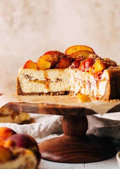 the inside of a sliced peach cobbler cheesecake with peaches baked inside