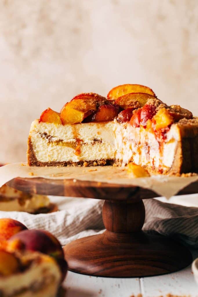 the inside of a sliced peach cobbler cheesecake with peaches baked inside