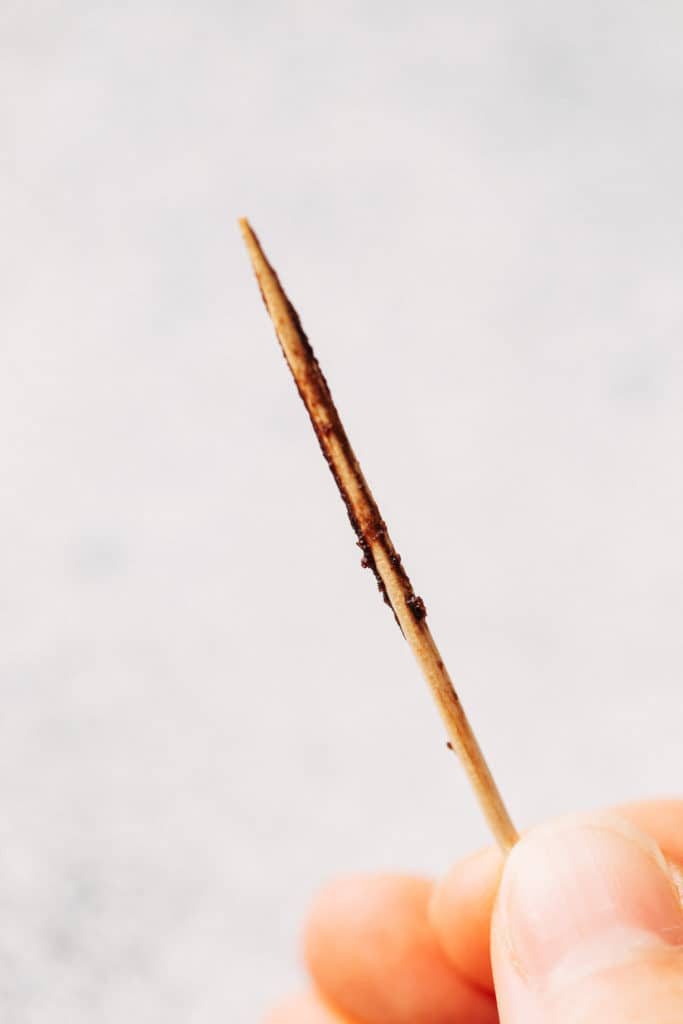 a toothpick pulled from a brownie cake layer