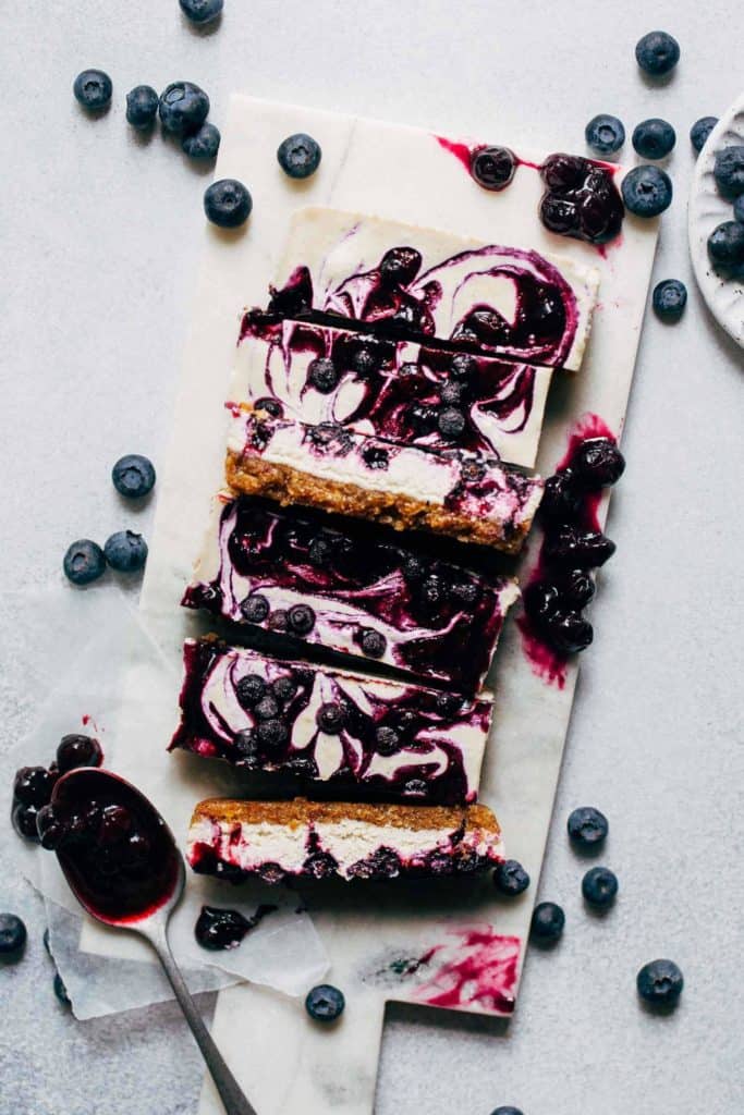 vegan blueberry cheesecake bars on a marble board