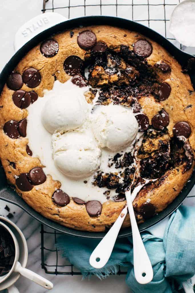 the top of a chocolate chip skillet cookie with spoons digging in