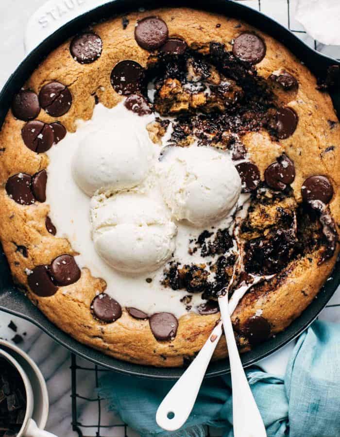 the top of a chocolate chip skillet cookie with spoons digging in