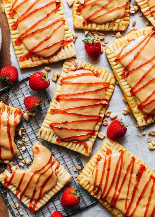 peanut butter and jelly pop tarts scattered on a sheet of parchment paper
