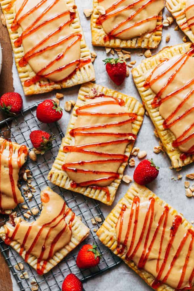 peanut butter and jelly pop tarts scattered on a sheet of parchment paper