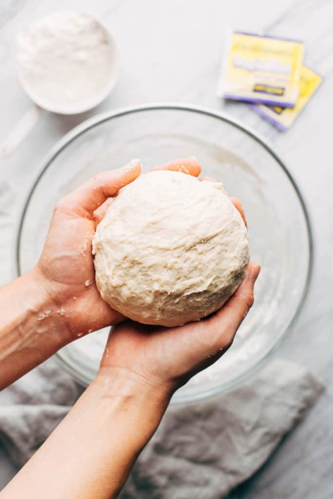 holding a ball of pizza dough