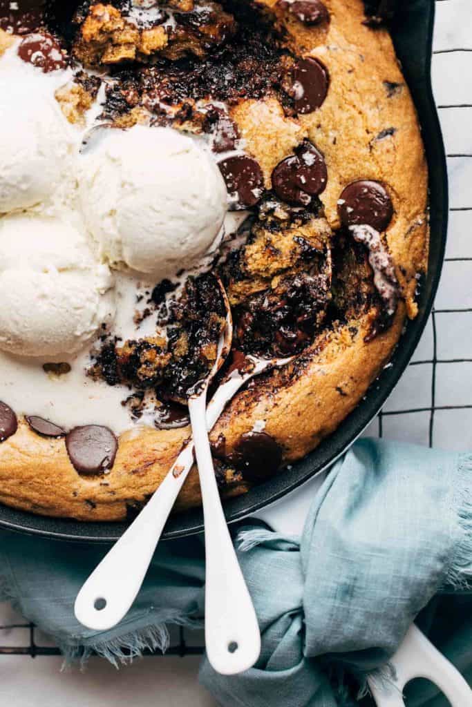 digging spoons into a warm skillet cookie
