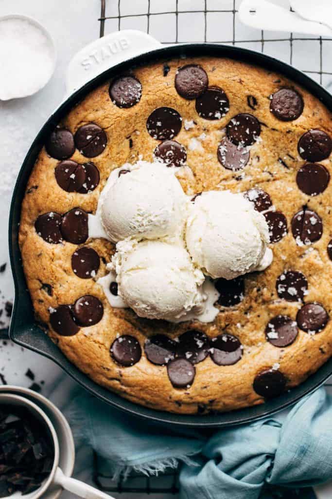 scoops of ice cream on top of a skillet cookie