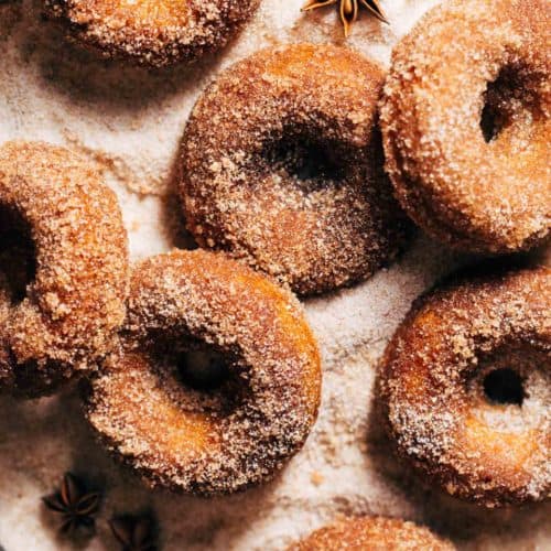 apple cider donuts in a bed of cinnamon sugar