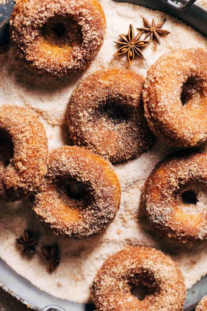 apple cider donuts in a bed of cinnamon sugar