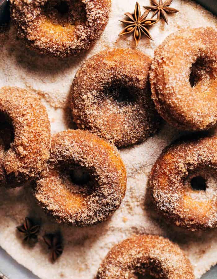 apple cider donuts in a bed of cinnamon sugar