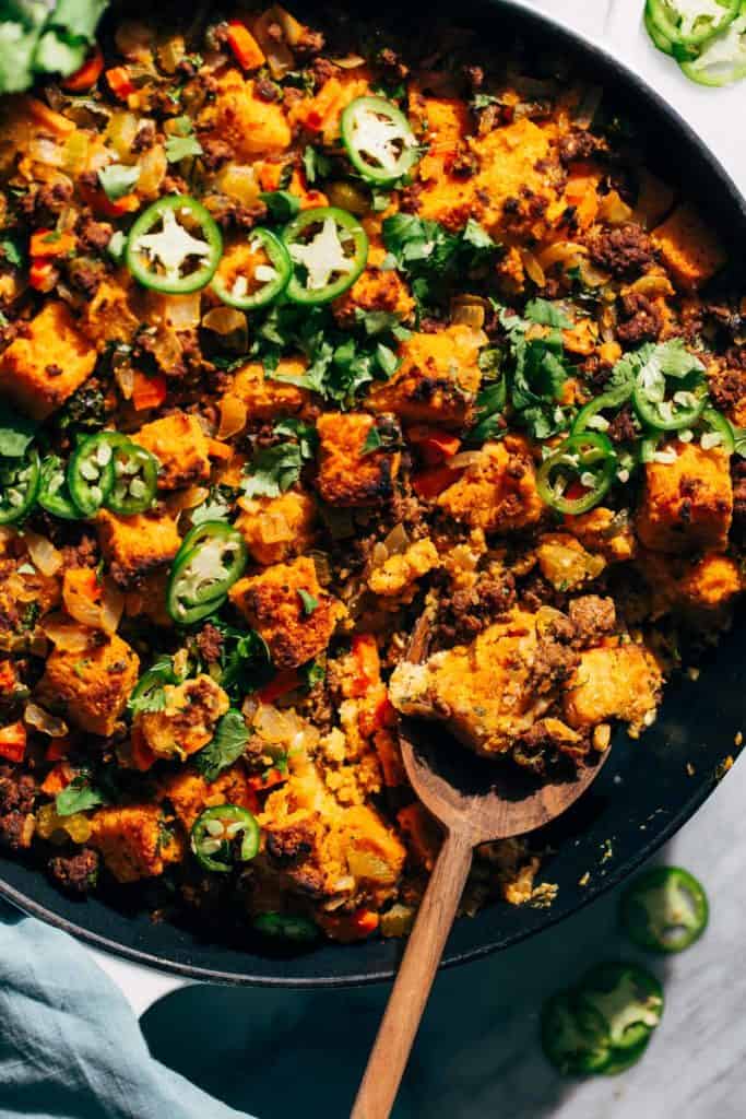 scooping out a spoonful of stuffing from a pan