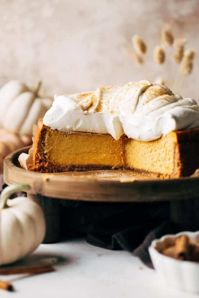 pumpkin cheesecake on a wood serving stand