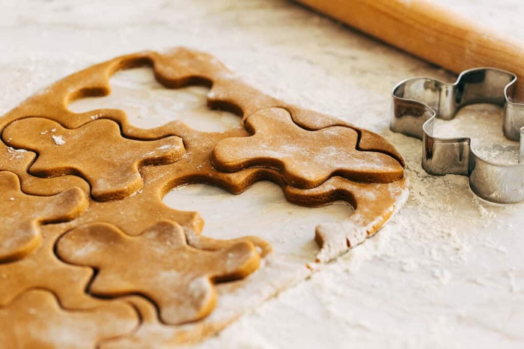 cutting gingerbread cookie men from the dough