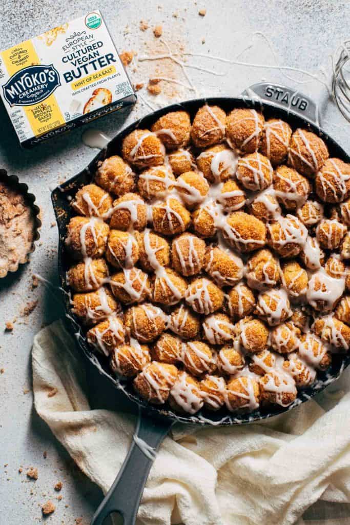 vegan monkey bread in a skillet, drizzled with icing