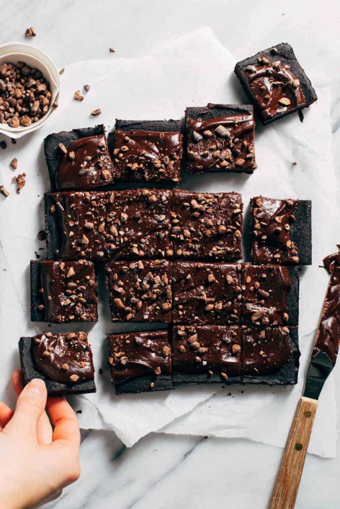 grabbing a piece of sliced chickpea brownies