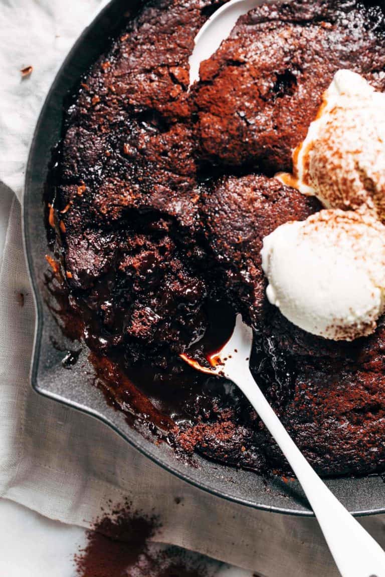 a spoon inside a skillet of chocolate pudding cake