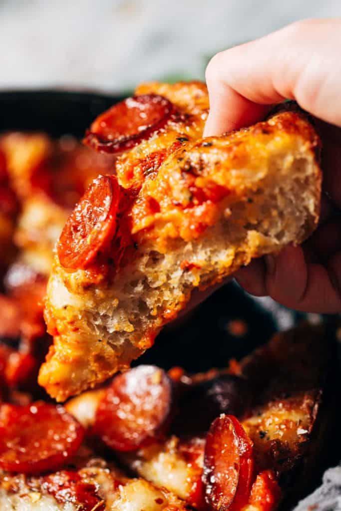lifting a slice of fluffy detroit style pizza