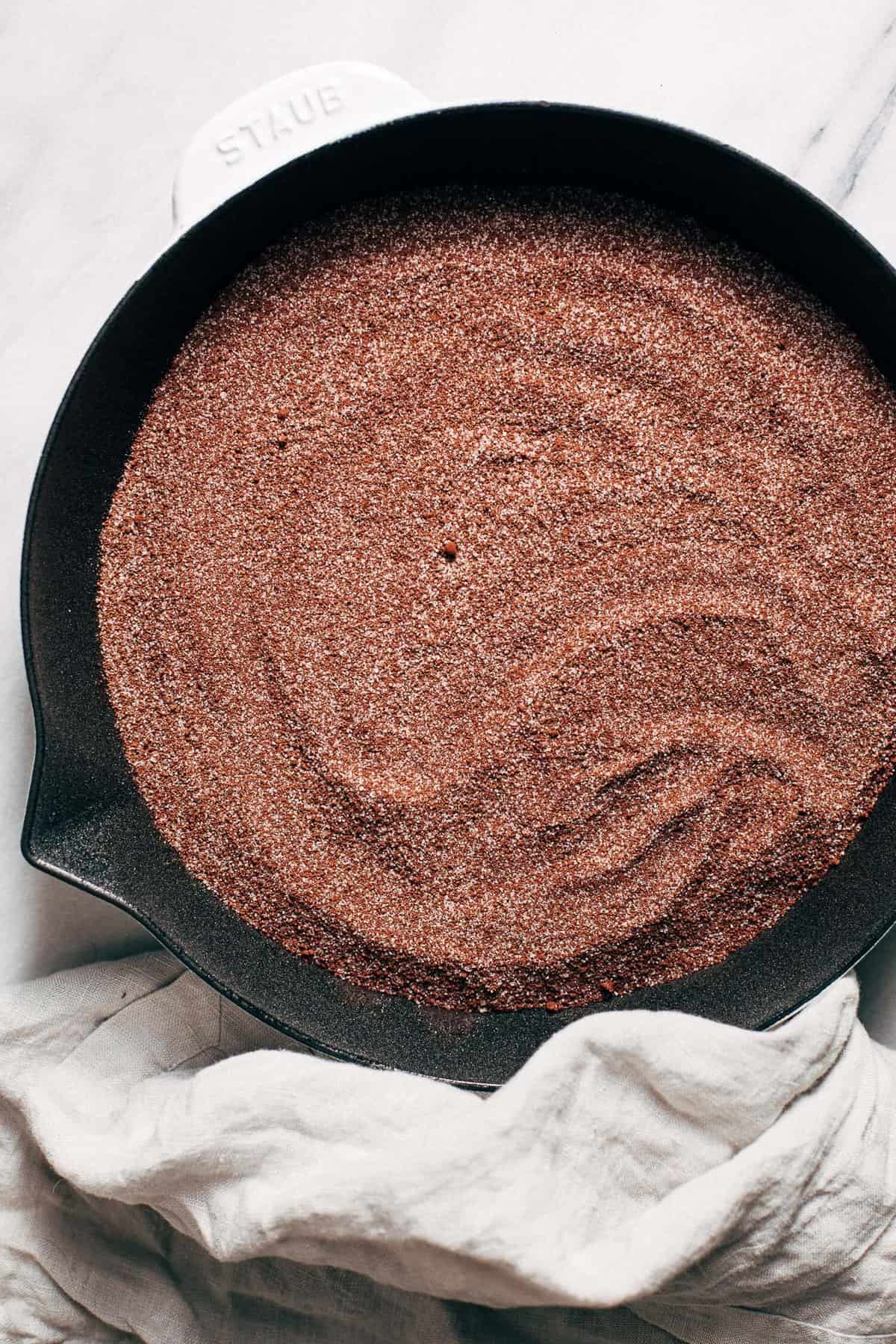 sugar and cocoa powder layered on top of chocolate cake batter