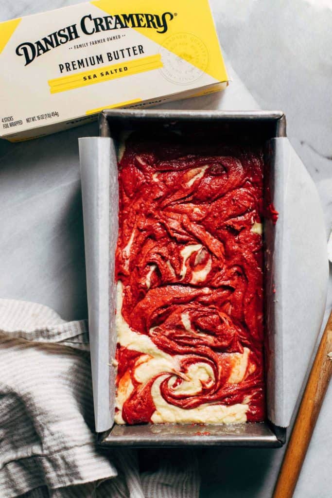 red velvet pound cake batter swirled in a loaf pan