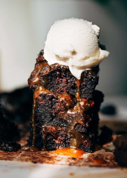 a stack of salted caramel brownies with ice cream on top