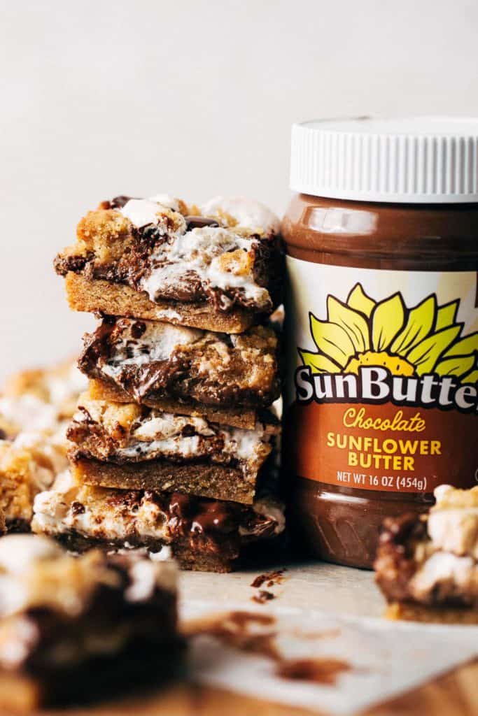 a stack of smores bars against a jar of chocolate sunbutter