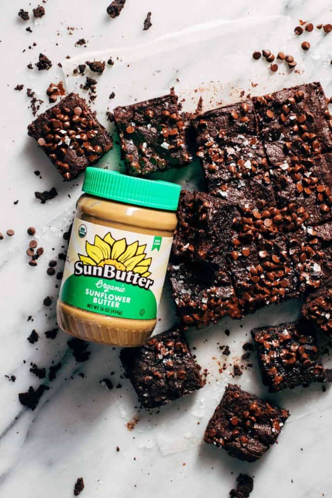 brownies scattered with a jar of sunflower seed butter