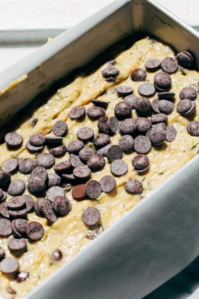 zucchini bread batter in a pan topped with chocolate chips