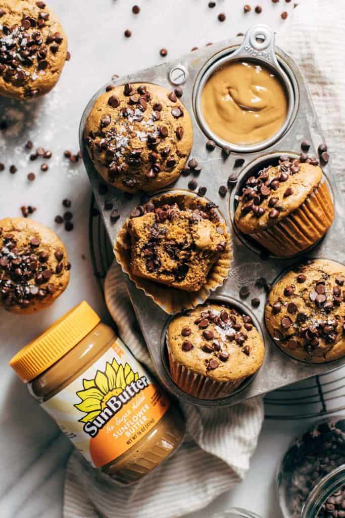 healthy zucchini muffins with a jar of sunflower seed butter