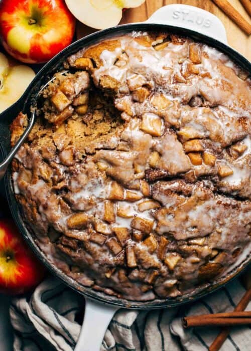 an apple fritter cake baked in a skillet with an icing glaze