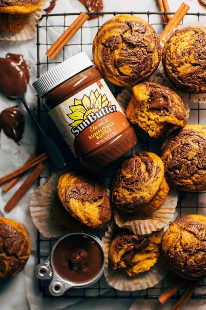 a jar of sunbutter with chocolate swirled pumpkin muffins