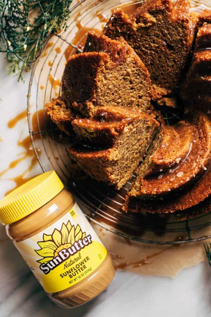 the top of a sliced banana bundt cake with a jar of sunbutter