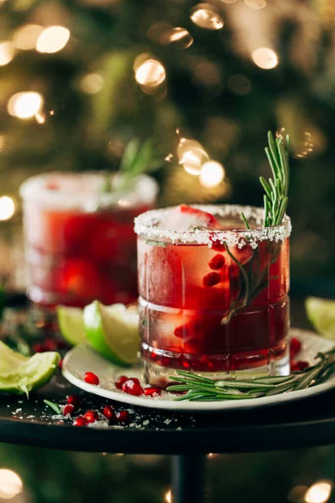 rosemary pomegranate margaritas in front of a Christmas tree