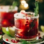 close up on a pomegranate margarita with a rosemary stem