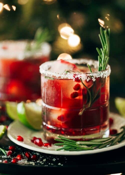 close up on a pomegranate margarita with a rosemary stem