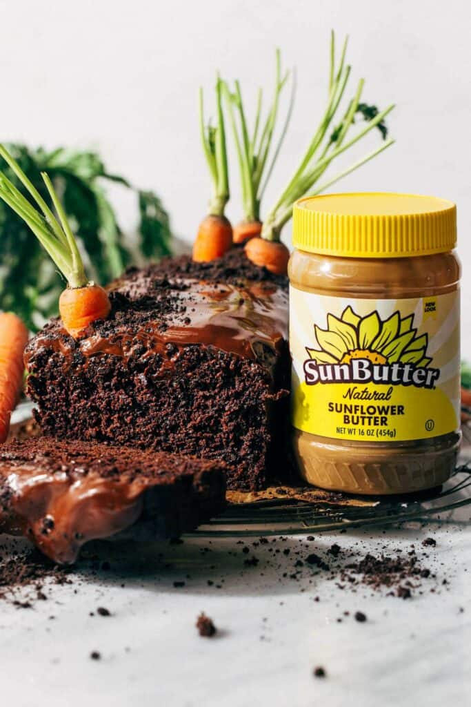inside a sliced chocolate carrot cake loaf with a jar of sunbutter