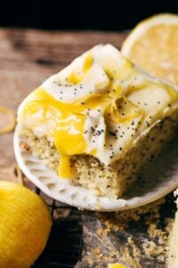 a slice of lemon poppy seed cake topped with lemon curd