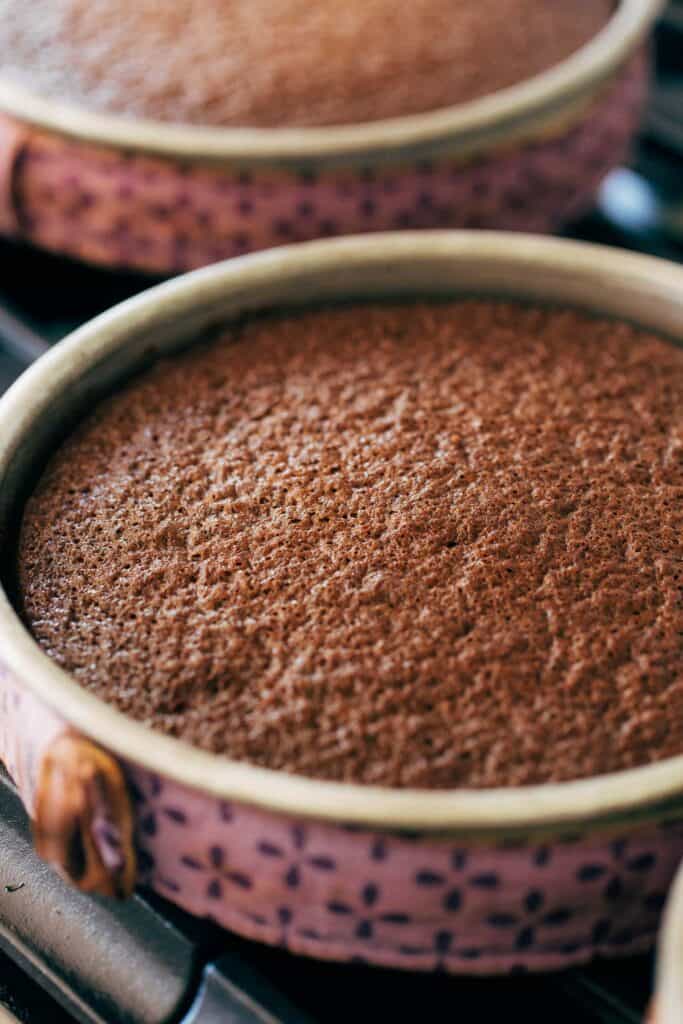 freshly baked chocolate cake layers still in their pans