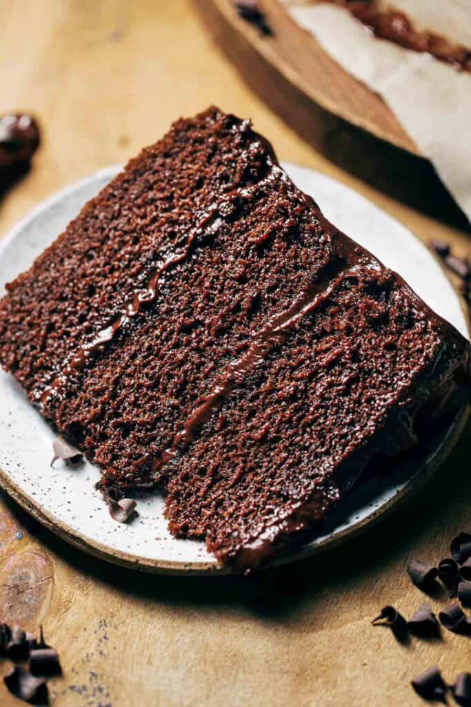 a slice of moist chocolate cake on a dessert plate