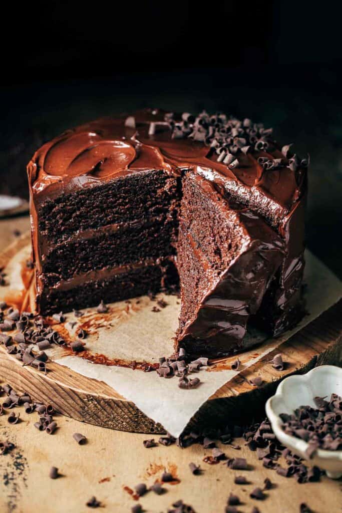 a three layer chocolate cake on a cake plate